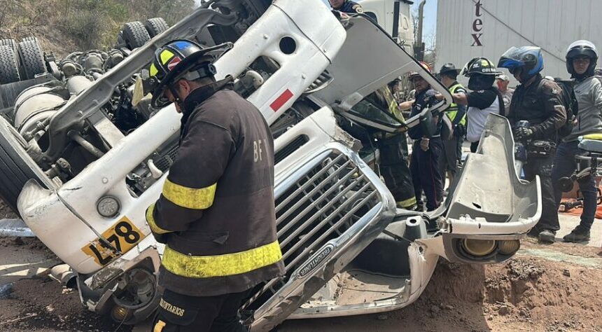 Rescatan con vida a piloto atrapado en camión volcado