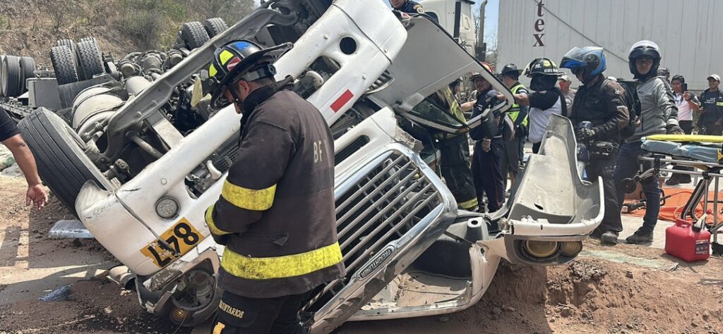 Rescatan con vida a piloto atrapado en camión volcado